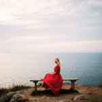 A woman sitting in stillness at sunrise, embodying the power of nothingness and the self-loving act of not acting
