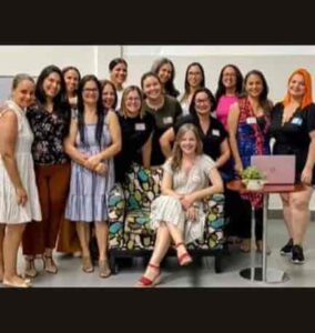 Grupo de mujeres asistentes al taller La Enfermedad Como Solución con Arlene De Angelis sentada en sillón al frente